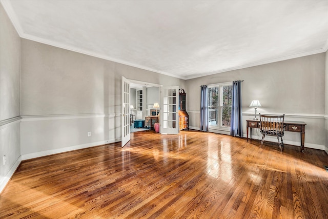 empty room featuring hardwood / wood-style floors, ornamental molding, and french doors