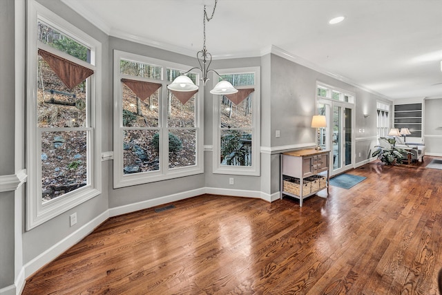 dining area with plenty of natural light, built in features, and an inviting chandelier