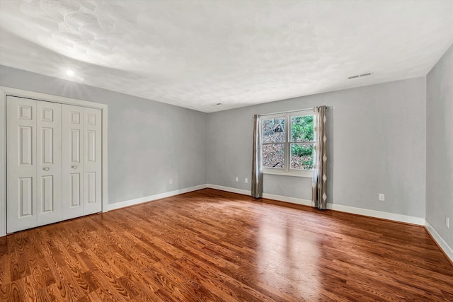 unfurnished bedroom with hardwood / wood-style floors and a closet