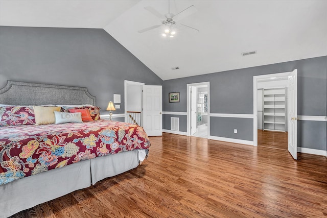 bedroom featuring ensuite bath, ceiling fan, high vaulted ceiling, a spacious closet, and hardwood / wood-style floors