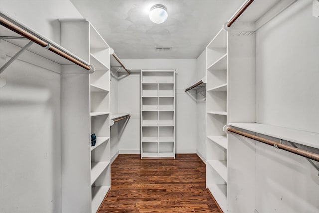 walk in closet with dark hardwood / wood-style flooring