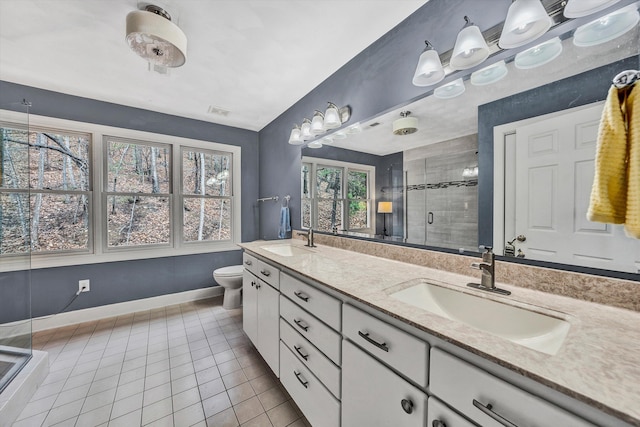 bathroom featuring tile patterned floors, vanity, a shower with shower door, and toilet