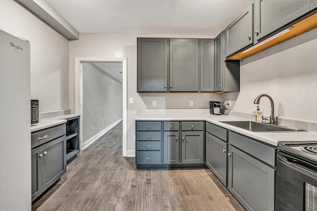 kitchen featuring gray cabinetry, sink, white fridge, and electric range oven