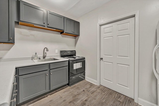 kitchen with black range with electric stovetop, sink, and gray cabinets