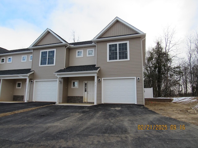 multi unit property with aphalt driveway, board and batten siding, and an attached garage