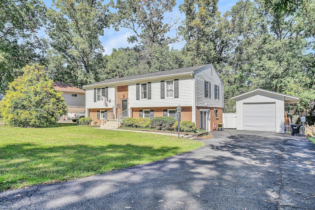 raised ranch featuring a front lawn, an outdoor structure, and a garage