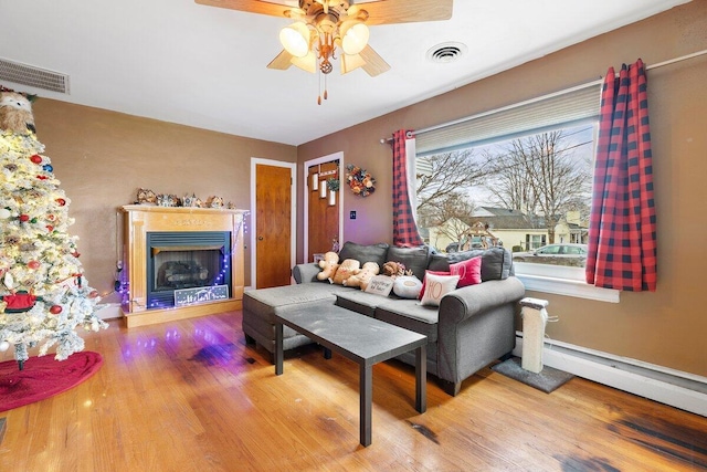 living room with a baseboard radiator, hardwood / wood-style flooring, and ceiling fan