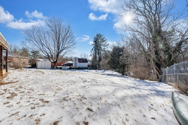 yard covered in snow with a storage unit