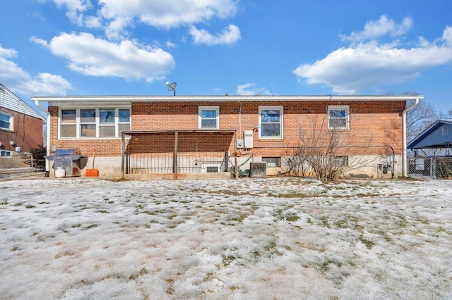 snow covered property with central AC