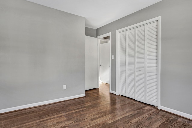 unfurnished bedroom with a closet and dark hardwood / wood-style floors