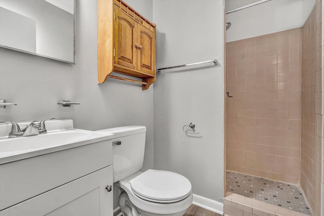 bathroom featuring tiled shower, vanity, and toilet