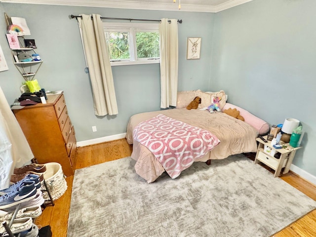 bedroom featuring hardwood / wood-style flooring and crown molding