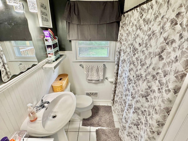 bathroom featuring tile patterned floors, sink, walk in shower, and toilet