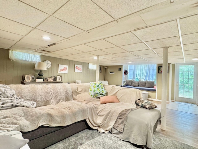 living room with hardwood / wood-style flooring, a drop ceiling, and a healthy amount of sunlight