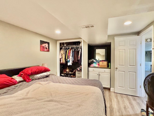 bedroom with light hardwood / wood-style flooring and a closet