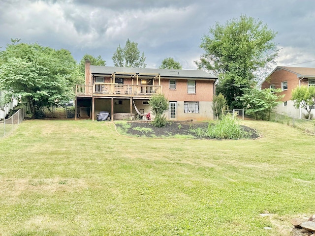 back of house featuring a lawn and a wooden deck