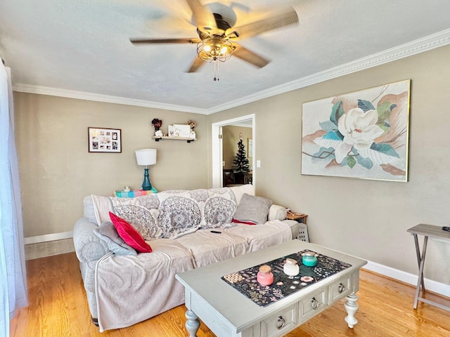 living room with light wood-type flooring, ceiling fan, and crown molding