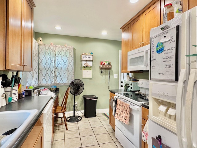 kitchen with light tile patterned flooring, white appliances, and sink