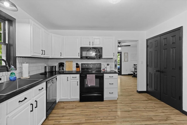 kitchen featuring tasteful backsplash, sink, white cabinets, and black appliances