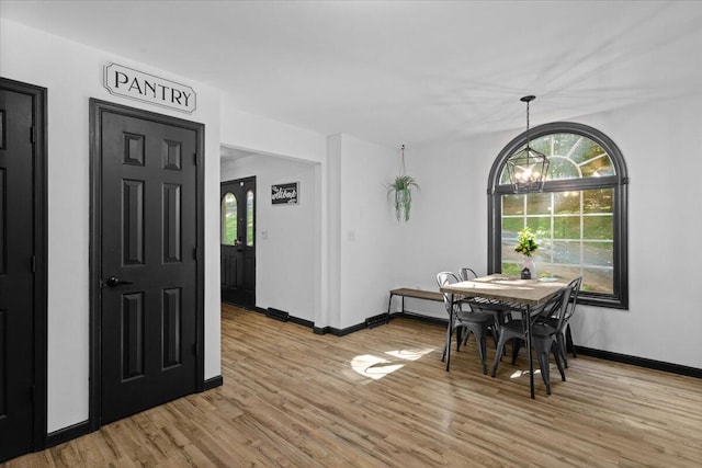 dining area featuring light hardwood / wood-style floors and an inviting chandelier