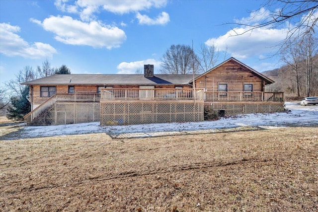 rear view of house featuring a wooden deck and a yard