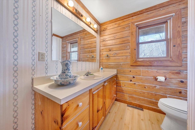 bathroom with wood-type flooring, vanity, and toilet