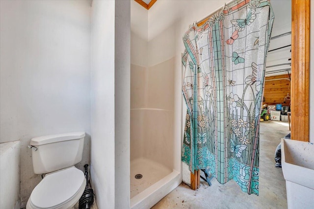 bathroom featuring toilet, concrete floors, and a shower with curtain