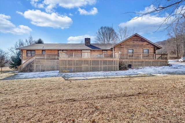 rear view of house with a lawn and a deck