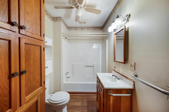 bathroom featuring a ceiling fan, toilet, wood finished floors, a textured ceiling, and vanity