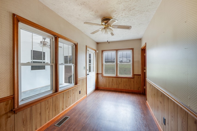 unfurnished sunroom featuring a ceiling fan and visible vents