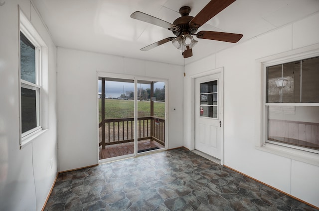 unfurnished sunroom with a ceiling fan