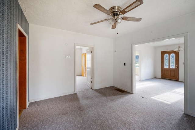 unfurnished room featuring visible vents, carpet flooring, ceiling fan, a textured ceiling, and baseboards