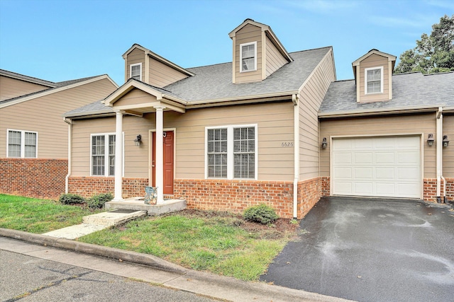 cape cod home featuring aphalt driveway, brick siding, an attached garage, and roof with shingles