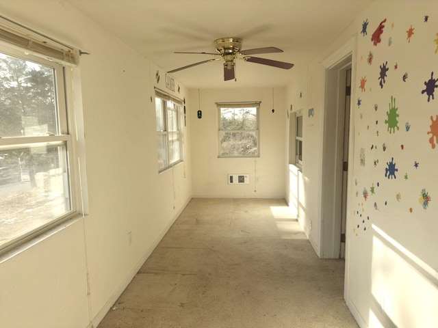 carpeted spare room featuring a wealth of natural light and ceiling fan