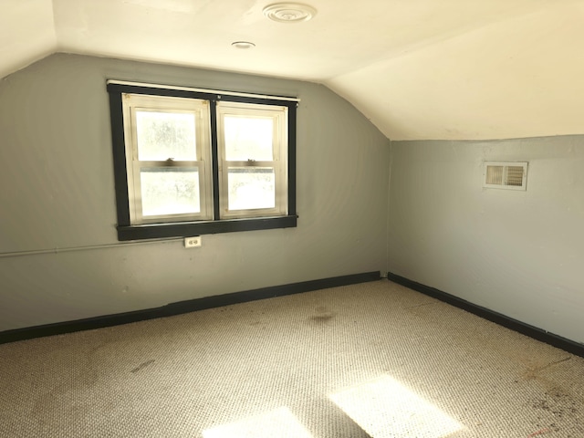 additional living space featuring lofted ceiling and carpet