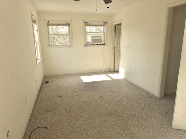 carpeted empty room featuring cooling unit and ceiling fan