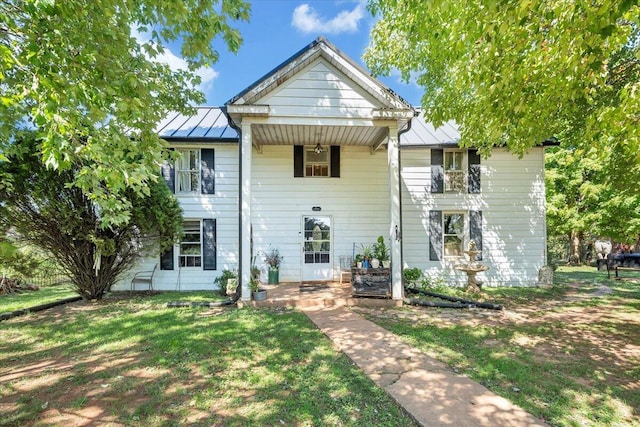 rear view of property featuring a balcony and a lawn