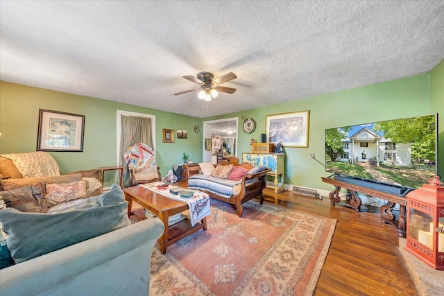 living room with a textured ceiling, hardwood / wood-style flooring, and ceiling fan