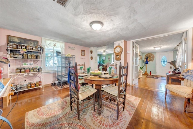 dining area featuring hardwood / wood-style floors and a textured ceiling