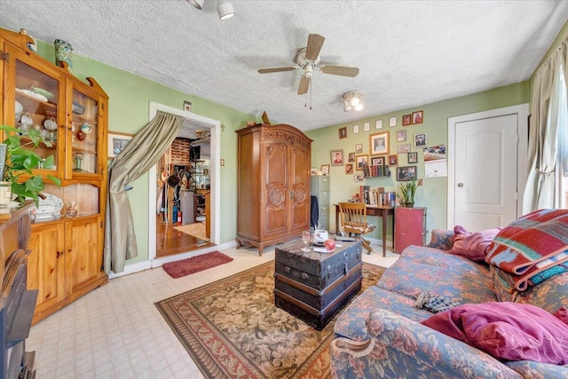 living room with ceiling fan and a textured ceiling