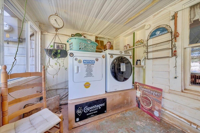 laundry room featuring washer and clothes dryer and wood walls