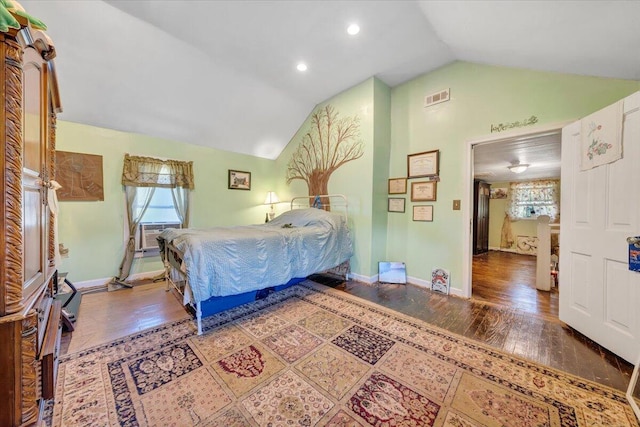 bedroom featuring wood-type flooring, multiple windows, and lofted ceiling