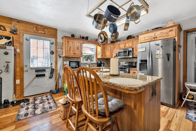 kitchen with a center island, light hardwood / wood-style floors, a healthy amount of sunlight, and stainless steel appliances