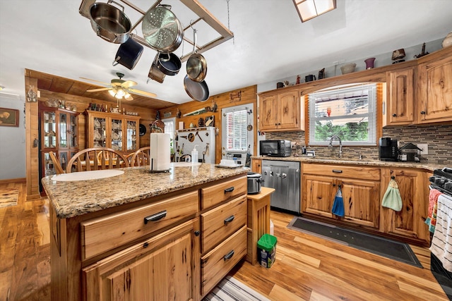 kitchen with a center island, black appliances, sink, ceiling fan, and light hardwood / wood-style floors