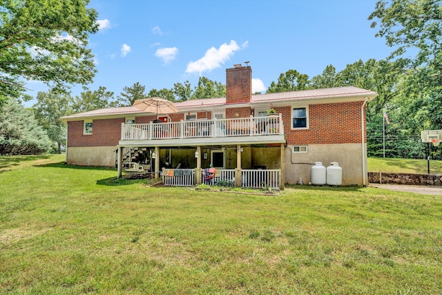 rear view of house featuring a lawn and a deck