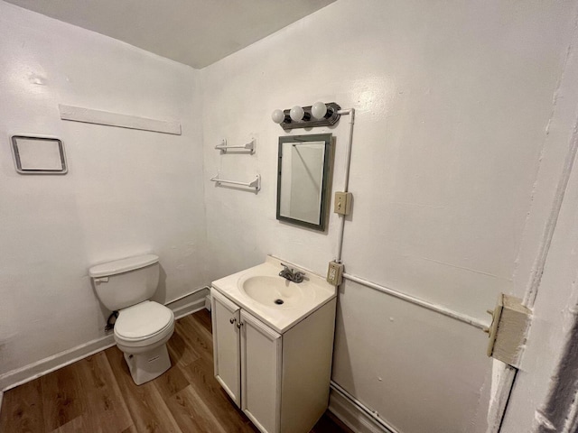 bathroom with hardwood / wood-style flooring, vanity, and toilet