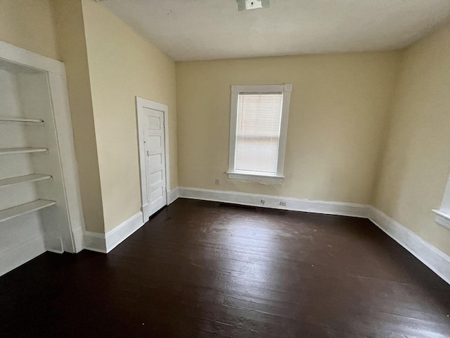 unfurnished bedroom with dark wood-type flooring