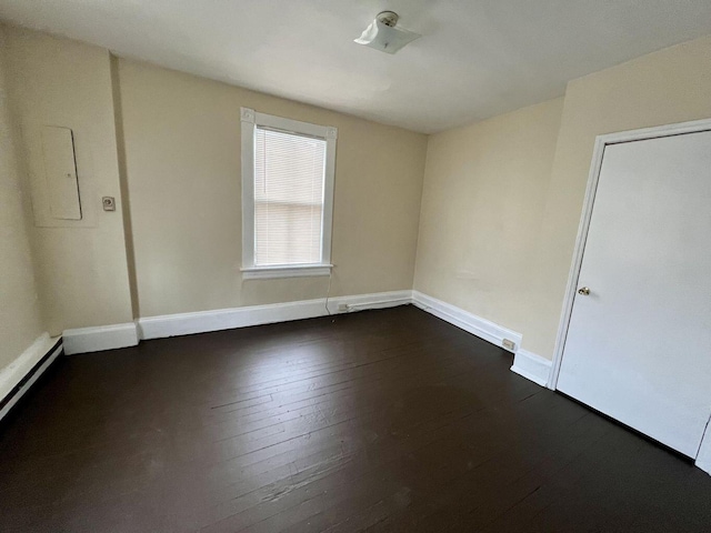 unfurnished room featuring dark hardwood / wood-style floors and electric panel