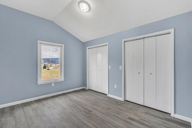 306 Carey Ave, Salem, VA 24153 - unfurnished bedroom with light hardwood / wood-style floors, lofted ceiling, and multiple closets
