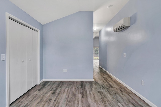 306 Carey Ave, Salem, VA 24153 - unfurnished bedroom featuring hardwood / wood-style floors, a wall unit AC, a closet, and lofted ceiling